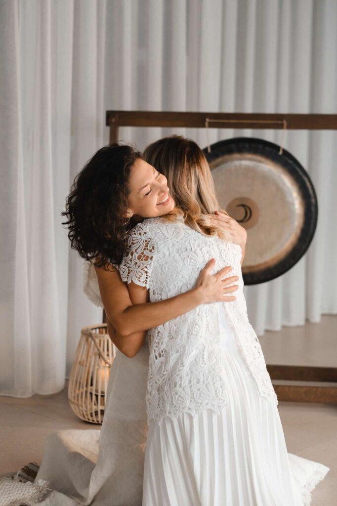 Two women hug at yoga. Women's Circle